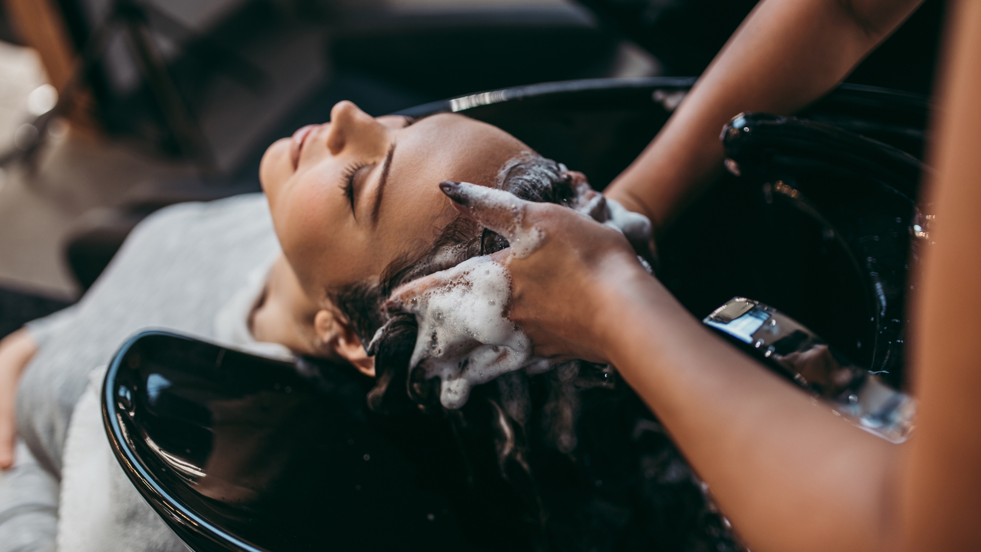 A woman getting her hair washed in a salon
