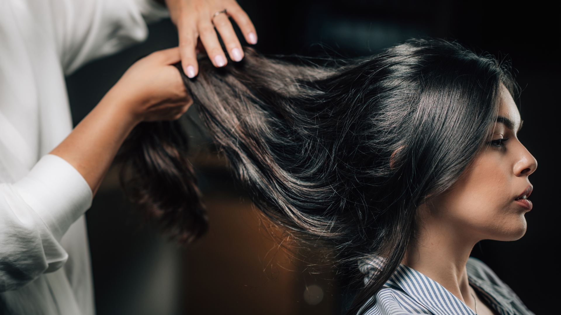 A woman is blow drying her hair