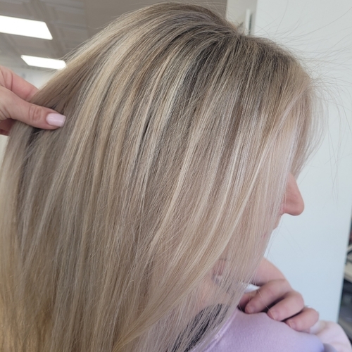 A woman with blonde hair getting her hair cut